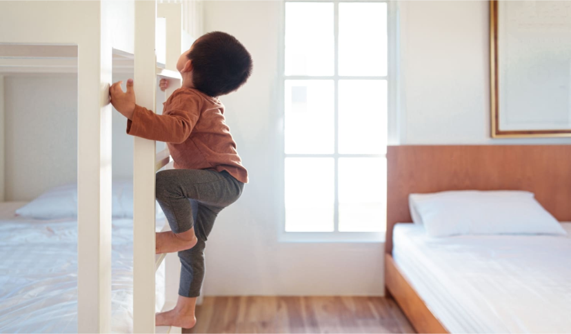 Un enfant grimpe sur un lit en étage